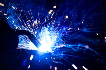 The process of welding metal in the dark with the formation of a large amount of smoke and sparks.