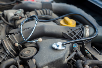 closeup of medical stethoscope on car engine. concept for auto service and repair