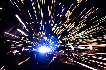 The process of welding metal in the dark with the formation of a large amount of smoke and sparks.