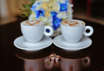 Cup of coffee and wedding rings