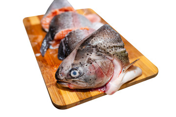 Raw salmon trout cut into pieces lying on a wooden board, isolated on a white background with a clipping path.