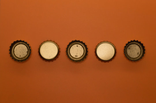 five bottle caps on orange background