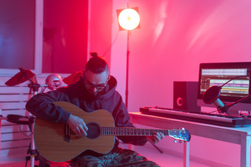 Create music and a recording studio concept - Bearded man guitarist recording electric guitar track in home studio