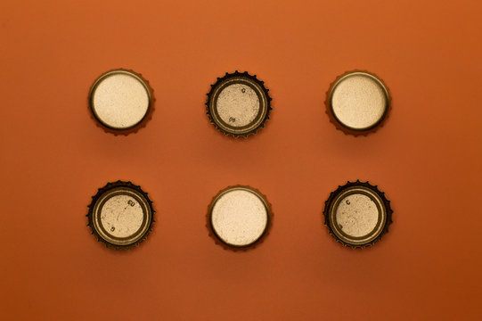 six bottle caps on orange background