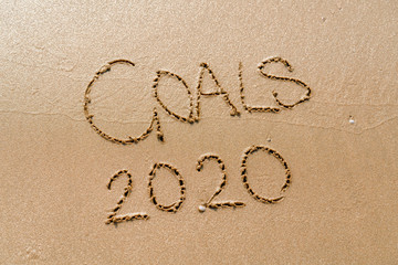 foamy sea water and Inscription Goals 2020 on the sandy beach
