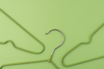 Flat lay with cloth hangers at green pastel background. Monochrom natural colours.