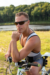 Fototapeta premium Man near a bicycle. On nature in the field.