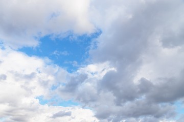 Gray and white fluffy clouds on a blue sky background