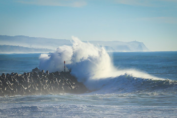 Big ocean wave hitting pier. Storm waves