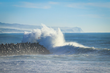 Big ocean wave hitting pier. Storm waves