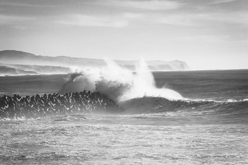Big ocean wave hitting pier. Storm waves