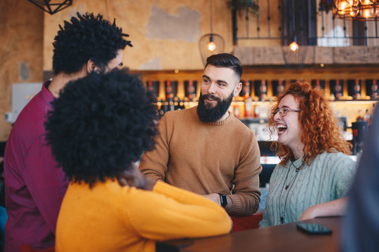 Four friends sitting in a cafe, talking and enjoying themselves.