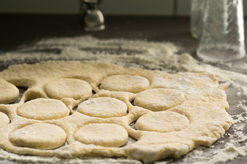 Fresh raw pastry cut into circles with a glass to make a homemade doughnuts, best sweet snack for Fat Friday - february European holiday