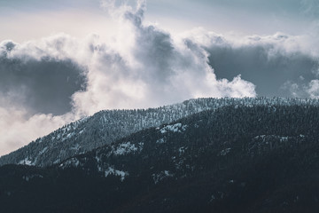 Heavenly sky twists clouds over snow covered mountain range. A Peaceful and tranquil landscape in...
