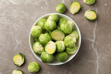Bowl with brussels sprout on grey background, top view