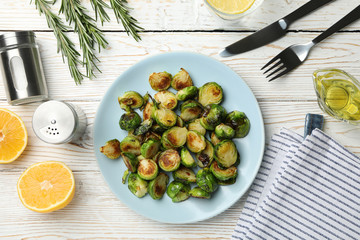 Composition with plate of brussels sprout on wooden background, top view