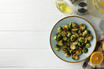 Composition with plate of brussels sprout on wooden background, top view