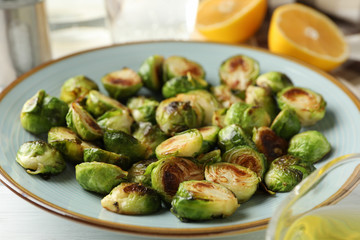 Composition with plate of brussels sprout on wooden background, close up