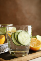 Composition with glasses of cucumber water on wooden table, space for text