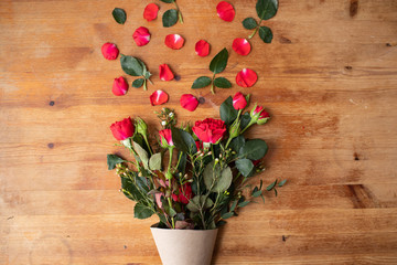 Beautiful flowers on a wooden table with an envelope. The work of the florist. Flower delivery