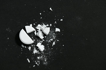 One broken white pill on black background macro photo - concept of medicine and medication...