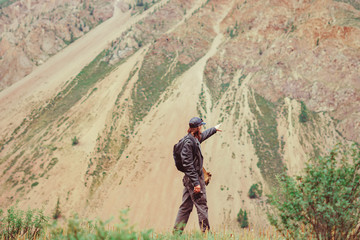 Obraz premium guy with a backpack near the mountains
