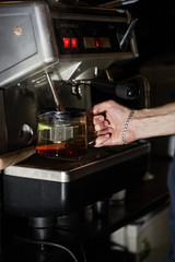 Fototapeta na wymiar bartender pours boiling water from coffee machine into author's tea