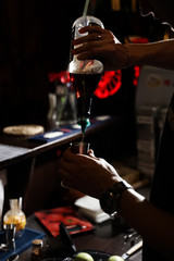 bartender pours caramel syrup for designer tea