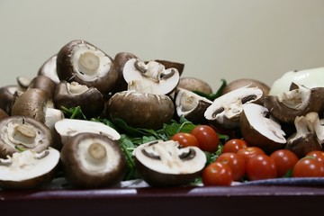 Still life from products: mushrooms, spinach, tomatoes small and large, onions side view
