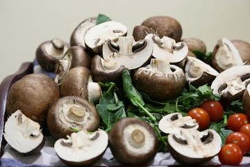 Still life from products: mushrooms, spinach, tomatoes small and large, onions side view