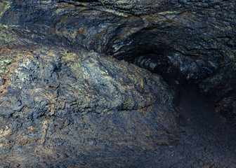 Sulfur Deposits shine like Gold ore embedded in rock in Valentine Cave, Lava Beds National Monument, CA, USA. Phosphatic materials emit a green yellow phosphorescence to glow under light