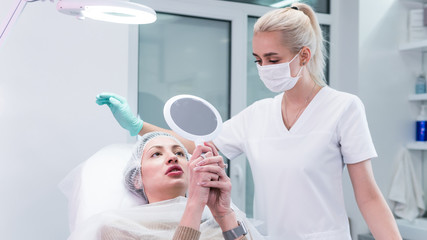 The young beautician doctor preparing to making injection in female lips. The doctor cosmetologist...
