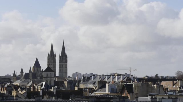 Cityscape of Caen in Normandy, France. The city is famous for its bell towers. View of the old town. Filmed in winter, cloudy sky.