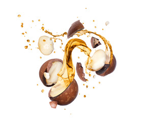 Crushed macadamia nuts with splashes of oil in the air, isolated on white background - obrazy, fototapety, plakaty