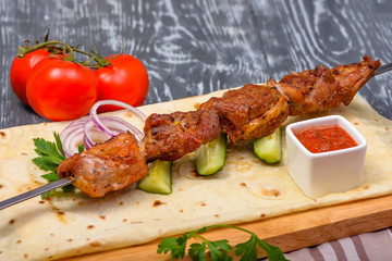 beef kebabs with fresh vegetables, sauces on lavas
