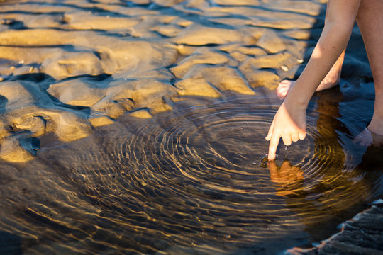 close up of young boys finger touching water. ,St Simon's Island