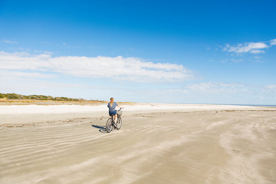 A teenage girl cycling on a beach,St Simon's Island