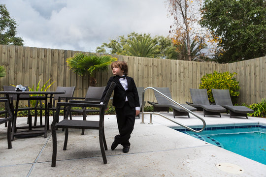 6 year old boy wearing formal attire standing by pool,St Simon's Island