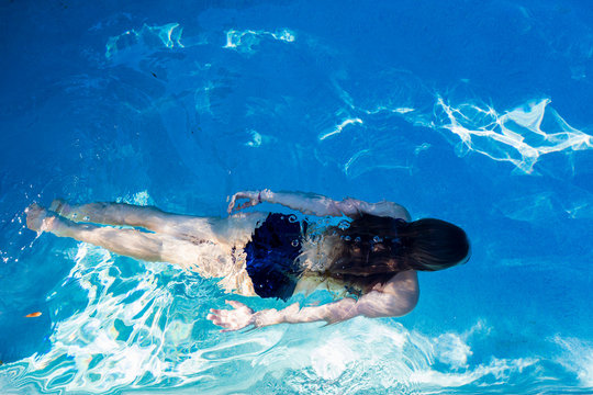 A teenage girl swimming in a pool, view from above.,St Simon's Island