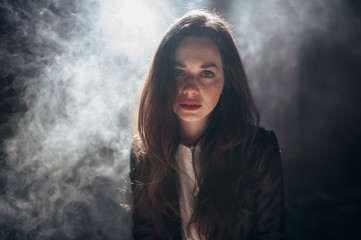 Fototapeta premium Brunette girl with red lipstick in the smoke.