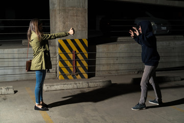 Obraz premium Bandit Raising Arms In Front Of Victim In Alley