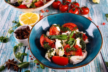 Freshly prepared Caprese salad with mozzarella, cherry tomatoes, Basil and arugula pesto.
