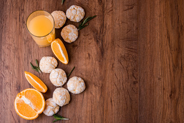 Fototapeta na wymiar Shortbread orange biscuits with sprigs of semarin, with fresh orange and juice on the table.