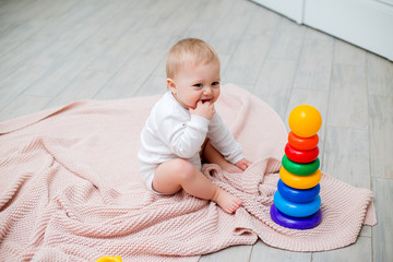 baby is sitting on the floor playing with educational toys