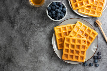 Belgian waffles with blueberry and honey for breakfast. Delicious homemade pastry. Copy space.