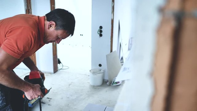 Handwerker schneidet grosse fliesen mit Fliesenschneider in einem neubau haus 4k Video in zeitlupe