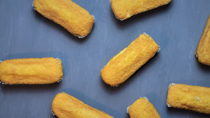 Madalenas rectangulares, esparcidas sobre tabla pintada