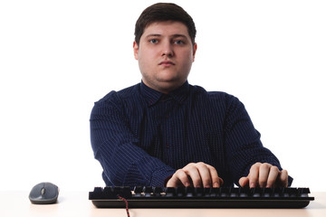 Young guy in a dark blue shirt types on the keyboard office, business on a white background. isolate. copy space