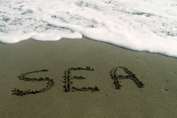 Word Sea written on beach sand