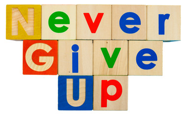 Inspirational NEVER GIVE UP concept spelled out in colorful toy alphabet  blocks.